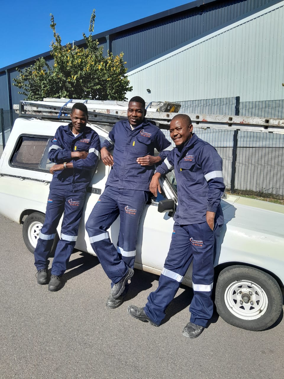 Magnificent Plumbers team in branded uniforms posing with their work truck