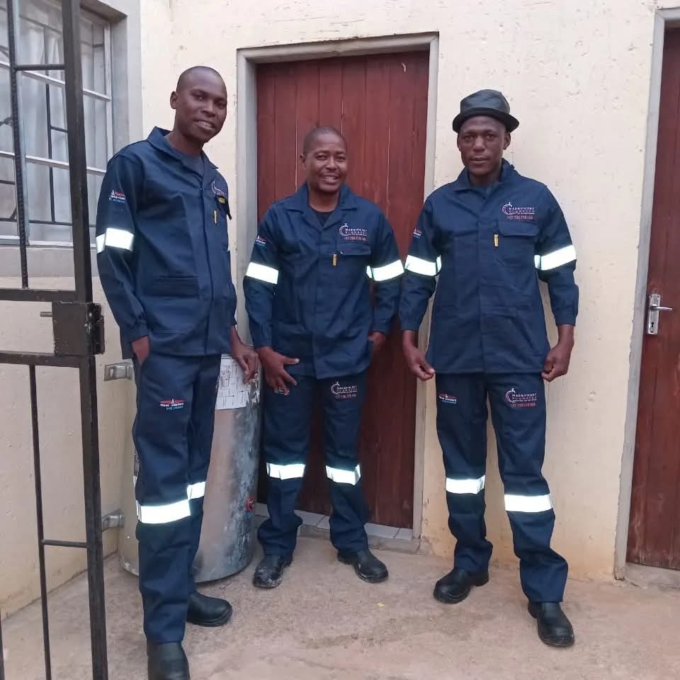 Three Magnificent Plumbers team members in branded uniforms posing together